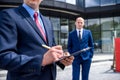 Business people signing contract near skyscraper outdoors Royalty Free Stock Photo