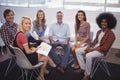 Business people sitting on chairs during meeting in creative office Royalty Free Stock Photo