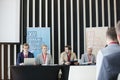 Business people sitting at desk in seminar hall Royalty Free Stock Photo