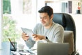 Business people are sitting at home, mobile, laptop and tablet on the table. Young man using tablet Royalty Free Stock Photo