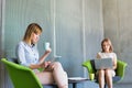 Business people sitting while using digital tablet, laptop while drinking coffee in lobby Royalty Free Stock Photo