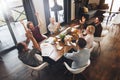 Business people sitting at a wooden table using laptops and paper document and applauding a successful concluded deal. Teamwork c Royalty Free Stock Photo