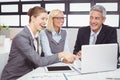 Business people smiling while discussing over laptop Royalty Free Stock Photo