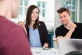 Business People Smiling While Looking At Colleague At Desk Royalty Free Stock Photo