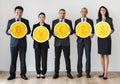 Business people standing and holding currency icons Royalty Free Stock Photo