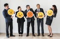 Business people standing and holding emoji icons Royalty Free Stock Photo