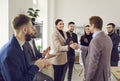 Business people standing in office making deal. Man shaking hands with woman finishing meeting. Royalty Free Stock Photo