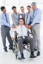 Business people supporting their colleague in wheelchair