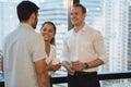 Business people talking and holding cups of coffee with city view .Group of coworkers having a coffee break in office.