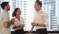 Business people talking and holding cups of coffee with city view .Group of coworkers having a coffee break in office. Royalty Free Stock Photo