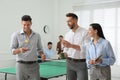 Business people talking near ping pong table in office Royalty Free Stock Photo