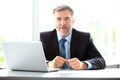 Business, people and technology concept - happy smiling businessman with laptop computer office Royalty Free Stock Photo