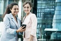 Business, people, tehnology and lifestyle concept: Two business women with mobiles near office