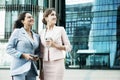 Business, people, tehnology and lifestyle concept: Two business women with mobiles near office