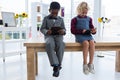 Business people using digital tablets while sitting on table in creative office Royalty Free Stock Photo