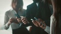 Business people using mobile phones together standing in office. Close up shot of human hands holding smartphones Royalty Free Stock Photo