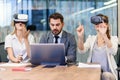 Business people using virtual reality goggles during meeting. Team of developers testing virtual reality headset and Royalty Free Stock Photo