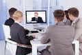 Business people in video conference at table Royalty Free Stock Photo