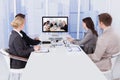 Business people in video conference at table Royalty Free Stock Photo