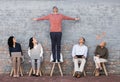 Business people, waiting room and man standing out for interview, meeting or opportunity against a brick wall. Group of