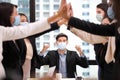 Business people wearing facial mask for new normal and social distancing policy doing high five to the new project