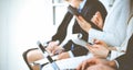 Business people working at meeting or conference, close-up of hands. Group of unknown businessmen and women in modern