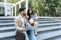 Business people working outside on laptop and tablet sitting on the stairs in front of office building. Colleagues businessman and Royalty Free Stock Photo