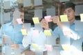 Business people working planning discussing idea with sticky reminder note on glass wall Royalty Free Stock Photo