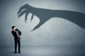 Business person afraid of a big monster claw shadow concept Royalty Free Stock Photo