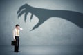 Business person afraid of a big monster claw shadow concept Royalty Free Stock Photo