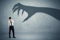 Business person afraid of a big monster claw shadow concept Royalty Free Stock Photo