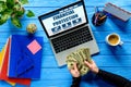 Business person counting dollars by laptop on blue wooden table with stationery Royalty Free Stock Photo