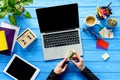 Business person holding dollars by laptop on blue wooden table Royalty Free Stock Photo