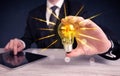 Business person holding an electric light bulb Royalty Free Stock Photo