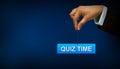 Business person holding quiz time sign on blue background