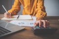 Business person sitting at a desk at an office By using the calculator to work. Business Concept Analysis and Planning