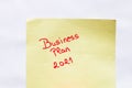 Business plan 2021 handwriting text close up isolated on yellow paper with copy space