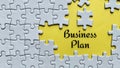 Business plan text on yellow background with white jigsaw puzzle missing pieces. Royalty Free Stock Photo