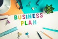 Business plan word on desk office background with supplies.