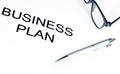 Business plan words near glasses and pen, business concept