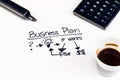 Business plan words near highlighters, calculator and cup of coffee, business concept Royalty Free Stock Photo