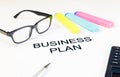 Business plan words near highlighters, calculator and glasses, business concept Royalty Free Stock Photo