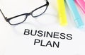Business plan words near highlighters and glasses, business concept