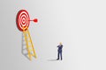 Miniature as businessman standing and looking to red dart hit target on dartboard. Royalty Free Stock Photo