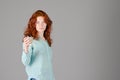 Business portrait of beautiful young woman with red curly hair and blue eyes against colorful background. Royalty Free Stock Photo