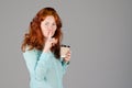 Business portrait of beautiful young woman with red curly hair and blue eyes against colorful background. Royalty Free Stock Photo