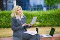 Business portrait of a blonde woman. Office worker working at a laptop outside. Royalty Free Stock Photo