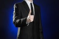 Business and the presentation of the theme: man in a black suit showing hand gestures on a dark blue background in studio isolated Royalty Free Stock Photo