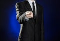 Business and the presentation of the theme: man in a black suit showing hand gestures on a dark blue background in studio isolated Royalty Free Stock Photo