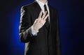 Business and the presentation of the theme: man in a black suit showing hand gestures on a dark blue background in studio isolated Royalty Free Stock Photo